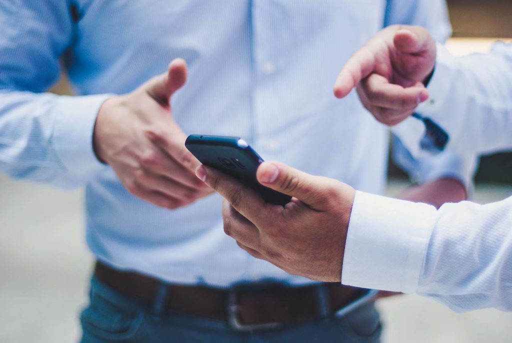 Men pointing at cell phone