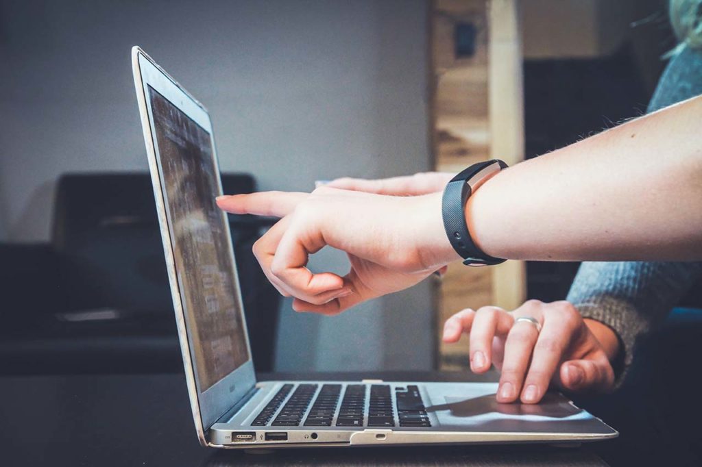 Man pointing at laptop screen